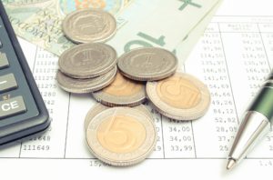 Polish currency money, calculator and pen on spreadsheet