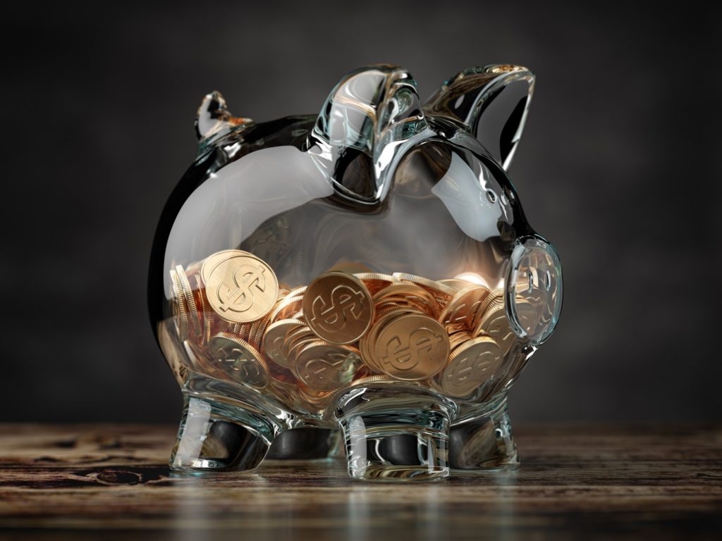Piggy bank with golden coins. Financial investment, savings and family budget concept background.
